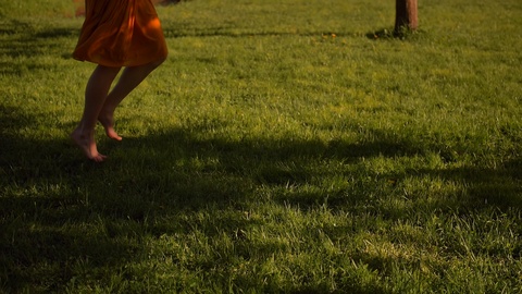 女性赤足在公园草地上跑步