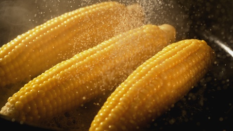 在煎锅上撒盐在玉米上慢动作
