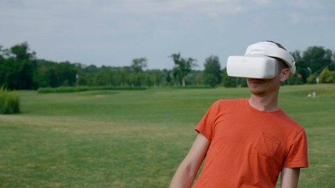 男人在高尔夫球场带着VR眼镜体验虚拟现实视频素材模板下载