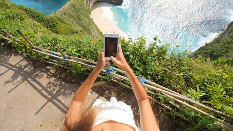 女孩用手机拍摄克林金海滩照片