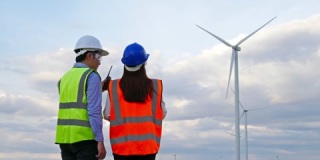 年轻的工程师团队在剪贴板上对风力涡轮机场进行报告。