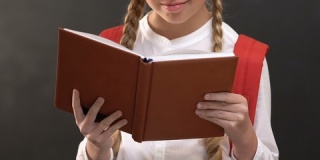 快乐的女生看书，对着黑板对着镜头微笑