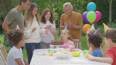 家庭在生日吹灭蜡烛后鼓掌的手持镜头视频素材模板下载
