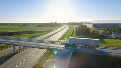 鸟瞰白色半挂车行驶在高速公路立交桥上