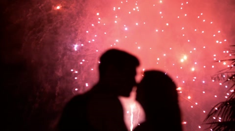 一对情侣在夜晚美丽的烟火背景下拥吻的剪影