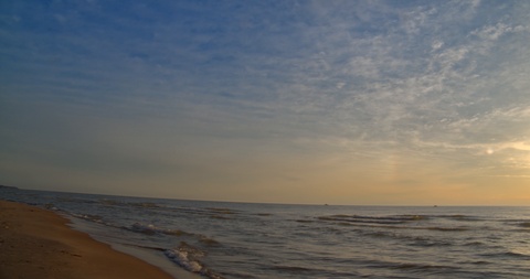 平移慢动作镜头，海浪在晚些时候轻轻卷起到海滩上