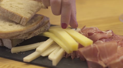 在石板上动态拍摄奶酪、面包、火腿、橄榄和一些红酒。视频素材模板下载
