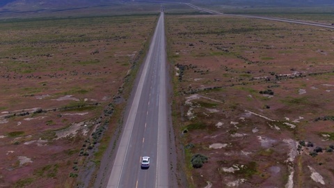 4K无人机拍摄跟随汽车驶过空旷公路视频素材模板下载