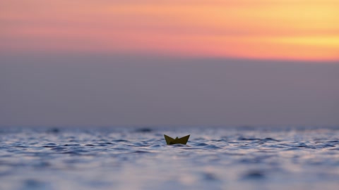 玩具船独自在海水中航行，纸船上的焦点选择性聚焦