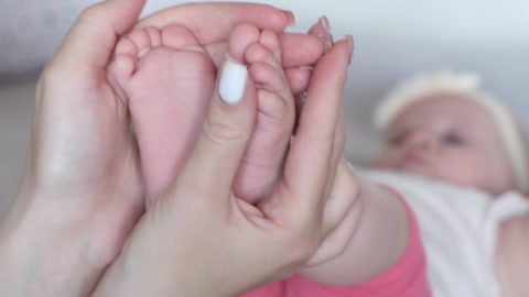 婴儿的脚在母亲手中。婴儿的脚在女性手上，形状为视频素材模板下载