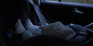 小男婴坐在汽车座椅上，坐在汽车后排座位上
