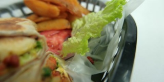 塑料篮子里的辣猪肉卷饼和莴苣