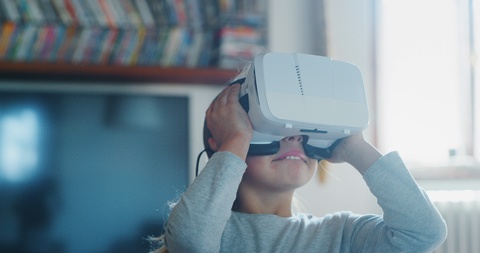 小女孩用VR眼镜体玩游戏