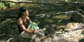 夏天坐在河边的亚洲女人