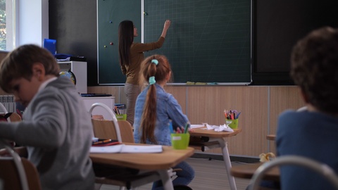 女教师在黑板上写数学方程式视频素材模板下载
