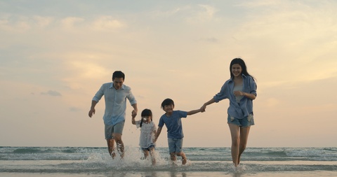 四口之家幸福的在海边游玩