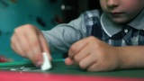 白人男孩学龄前儿童在家时在黑板上画粉笔。Se高清在线视频素材下载