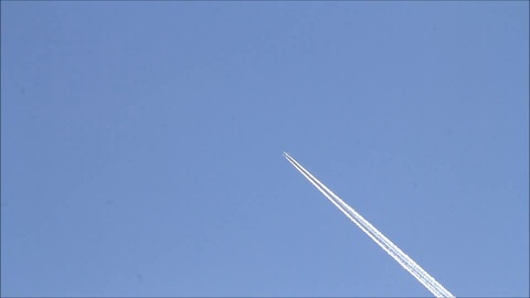 在蓝天中有航班留下的凝结尾迹的飞机