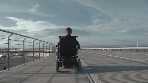 电动轮椅上的残疾男孩在户外