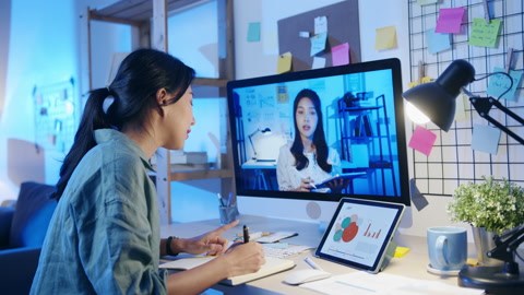 亚洲女商人使用桌面在视频通话中与同事谈论计划。
