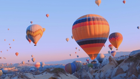 热气球飞过土耳其卡帕多西亚的山区