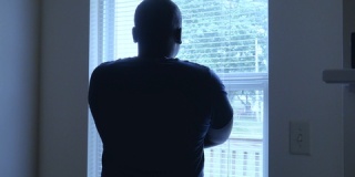 一个人站在窗前沉思