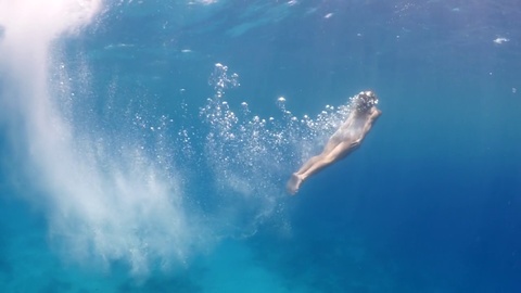女人跳入大海游泳
