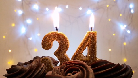 在生日蛋糕上点燃金色蜡烛，形状为数字34视频素材模板下载