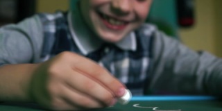 微笑的高加索男孩学龄前儿童在家用粉笔在黑板上写字，孩子