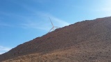 在偏远的阿拉伯沙漠和山区旋转的风力涡轮机高清在线视频素材下载