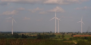 to their livestock, massive wind turbines tower above the fields. 风力涡轮机矗立在农田上方，农民在种植庄稼和照顾家畜的同时，这些巨大的风力涡轮机高耸在田野上方
