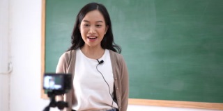 亚洲女教师与针麦克风在课堂教学在线工作。