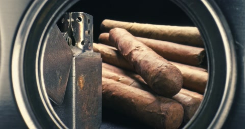 雪茄在保湿盒里，透过雪茄切割器看到打火机