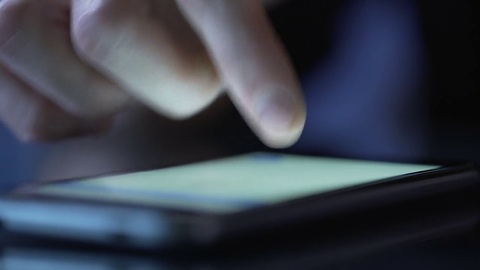 人的手在智能手机触摸屏上打字发短信，使用移动应用程序