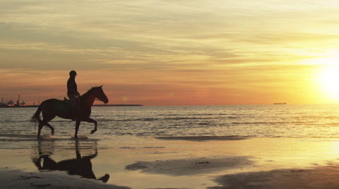 日落时分海滩的骑马者