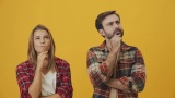 一对思考的夫妇站在黄色工作室里想出了主意高清在线视频素材下载