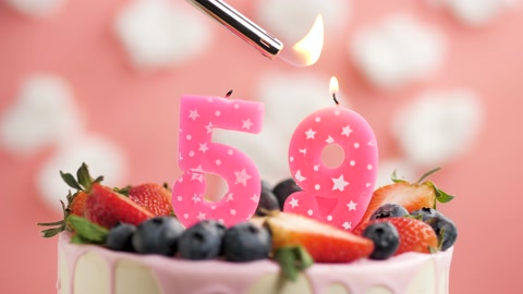 59号生日蛋糕蜡烛。蜡烛和蛋糕在粉色背景和火视频素材模板下载
