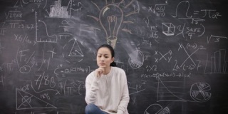 4K坐在黑板前思考数学公式的女人的肖像