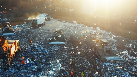 城市垃圾填埋场的空中视图垃圾车卸下垃圾推土机压碎垃圾