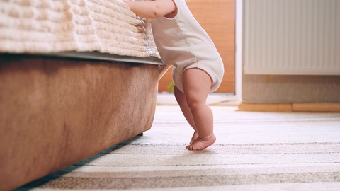 漂亮的婴儿脚学会走路。小脚在地板上行走。婴儿第一步视频素材模板下载