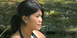 夏天坐在河边的亚洲女人