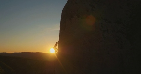 在惊人的日落时攀岩