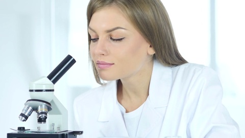 女科学研究员在实验室从事显微镜工作视频素材模板下载