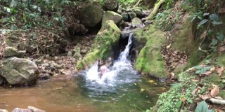 一个人跳进了一个小瀑布底部的小池塘4K