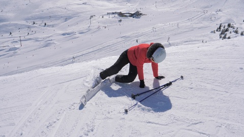 滑雪者摔倒在滑雪场上试图站起来特写镜头