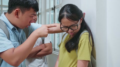 亚洲年轻学生欺负戴眼镜的白人女孩