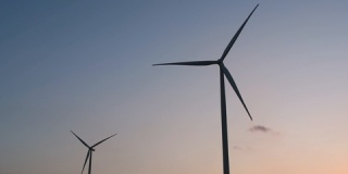 能源：在日落时分，风力涡轮机剪影在蓝色天空中，洁净能源