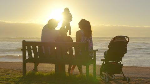 日落时分，快乐的家庭孩子们在一起。公园里的人概念爸爸妈妈视频素材模板下载