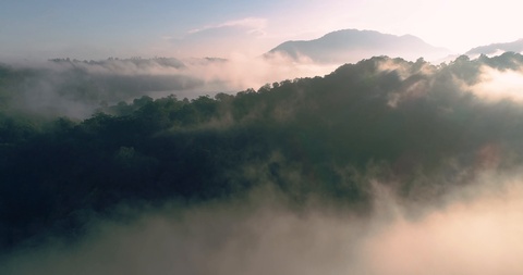 空中俯瞰无人机从云层中升起，俯瞰着山脉和湖泊