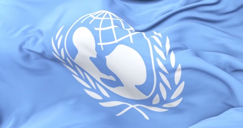 联合国儿童基金会的旗帜在慢慢风中飘荡在蓝天下，循环播放